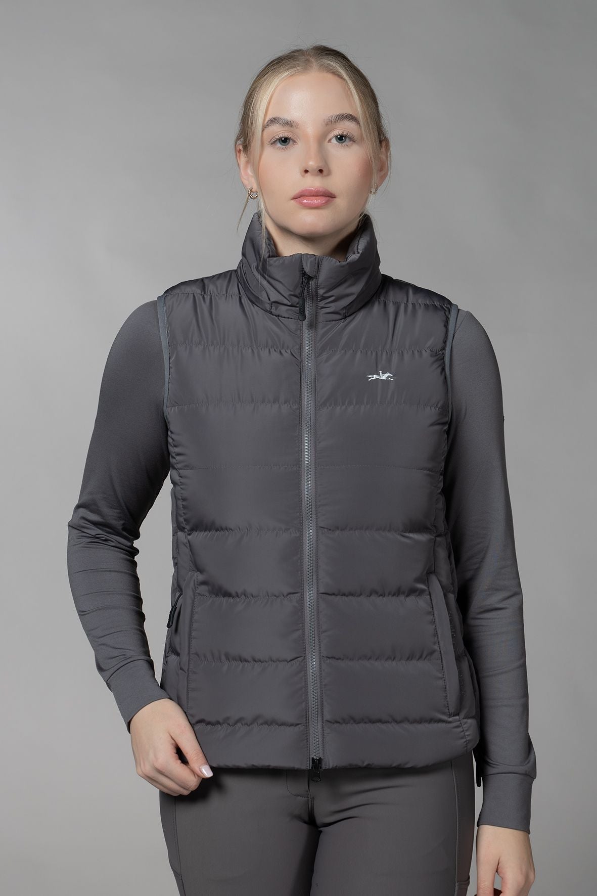 Schockemöhle Sports SPMalea Style Womens Vest - Gray aka Dusty Chocolate, worn by woman with gray base layer & pants on light gray background | Malvern Saddlery