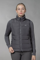 Schockemöhle Sports SPMalea Style Womens Vest - Gray aka Dusty Chocolate, worn by woman with gray base layer & pants on light gray background | Malvern Saddlery