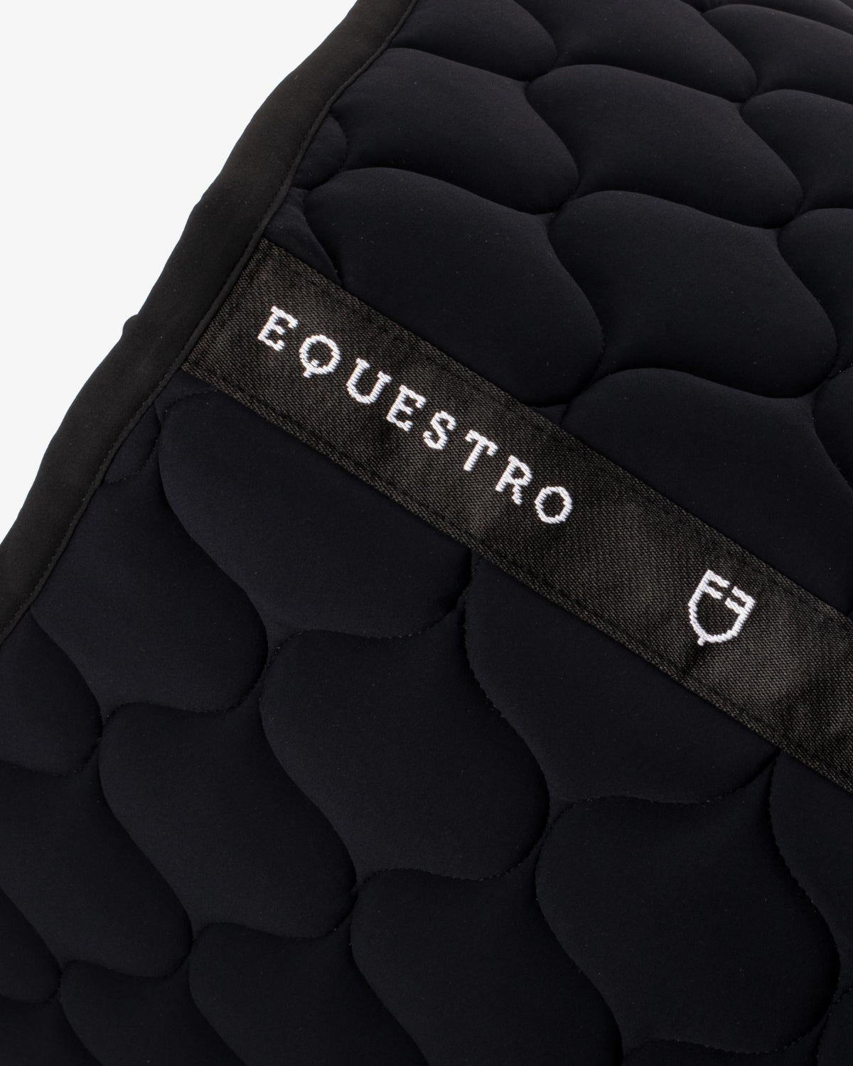 Equestro Circular Quilt Jump Saddle Pad; close up top seam logo | Malvern Saddlery