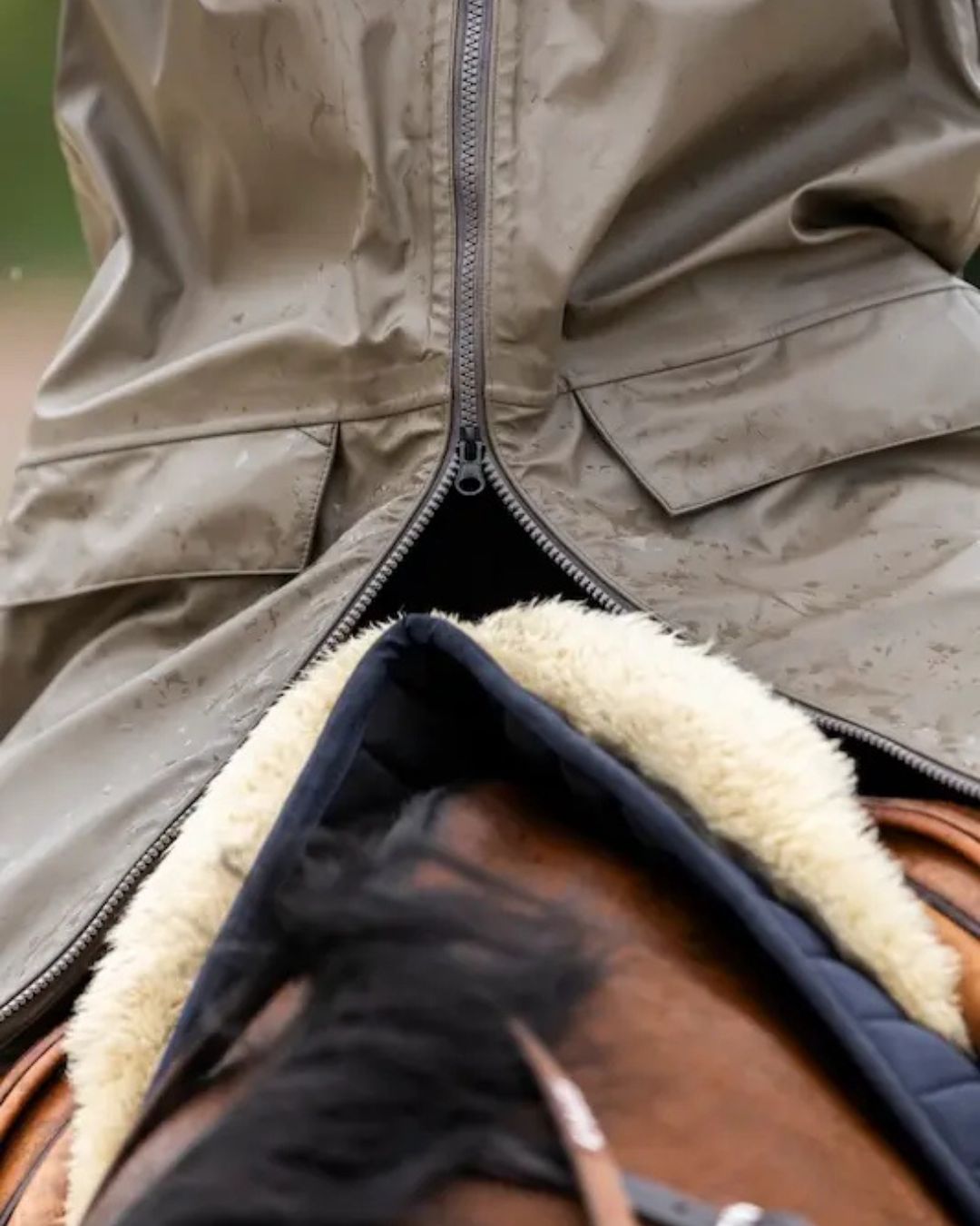 Horse Pilot Long Raintech Coat - Coffee brown - close up of bottom zipper adjusted for riding - worn by person sitting in saddle outdoors| Women's Outerwear | Malvern Saddlery
