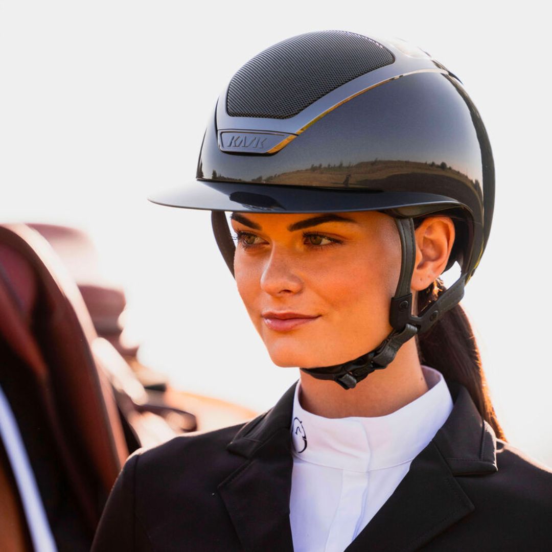 KASK Star Lady Pure Shine Equestrian Helmet - Anthracite Gray; close up lifestyle image shown on woman next to horse | English Riding Helmets | Malvern Saddlery