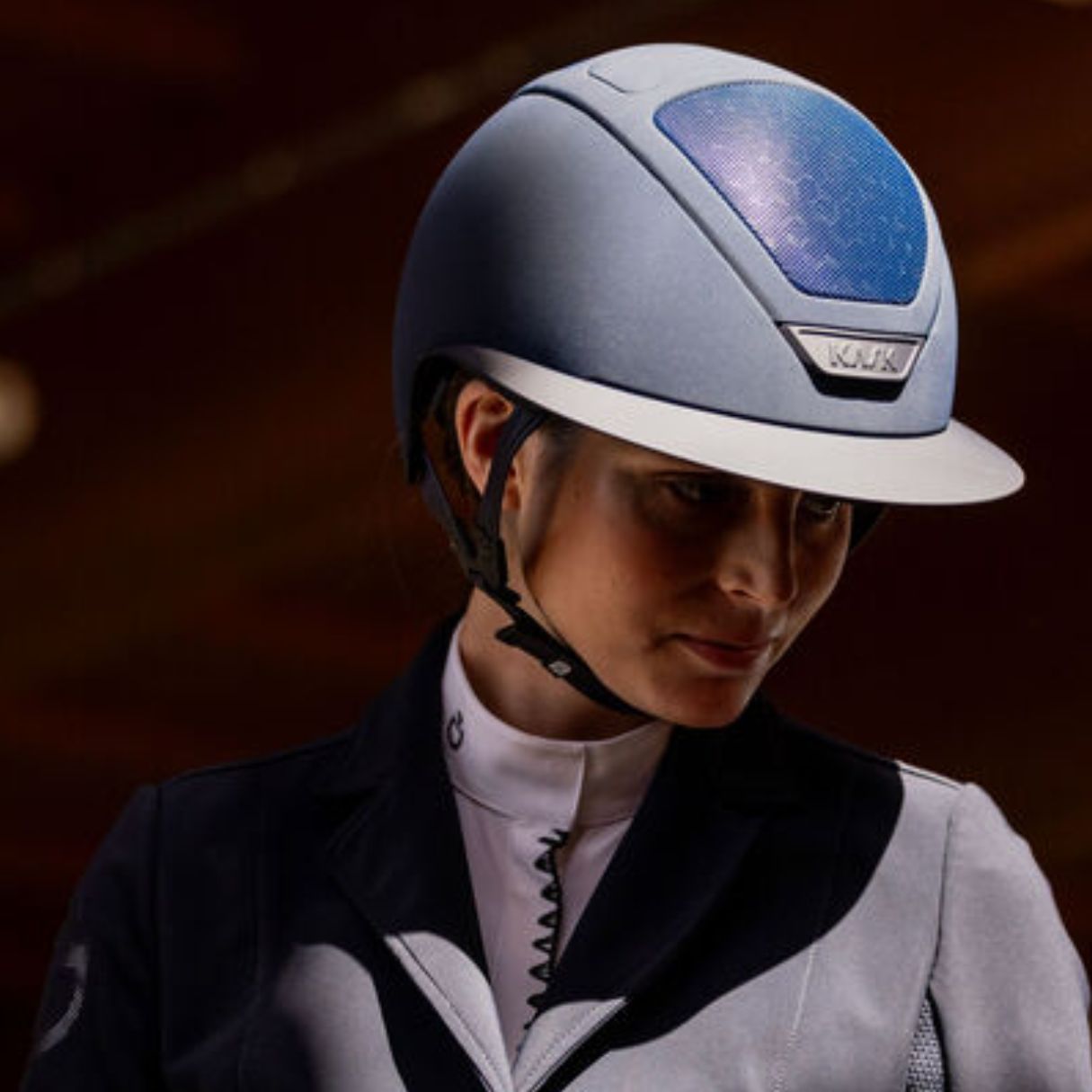 KASK Star Lady Hunter Equestrian Helmet - Navy; close up worn by rider wearing showcoat with blurred brown background | Wide Brim Helmets | Malvern Saddlery