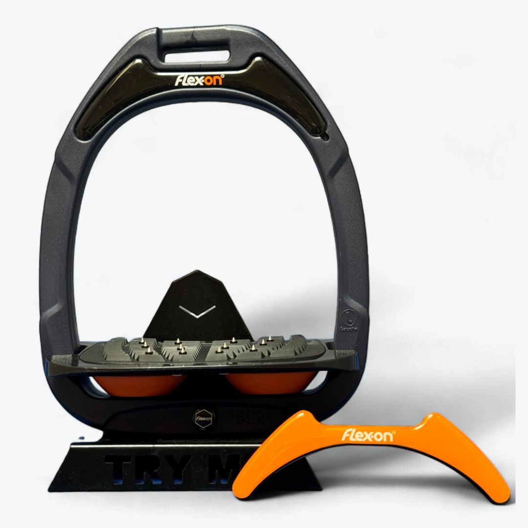 Dark Gray Flex-On GC2 composite stirrup with a black magnet featuring the Flex-on logo, a black footbed, and orange shock absorber, shown with an extra orange magnet sold separately  | Tack Shop | Malvern Saddlery