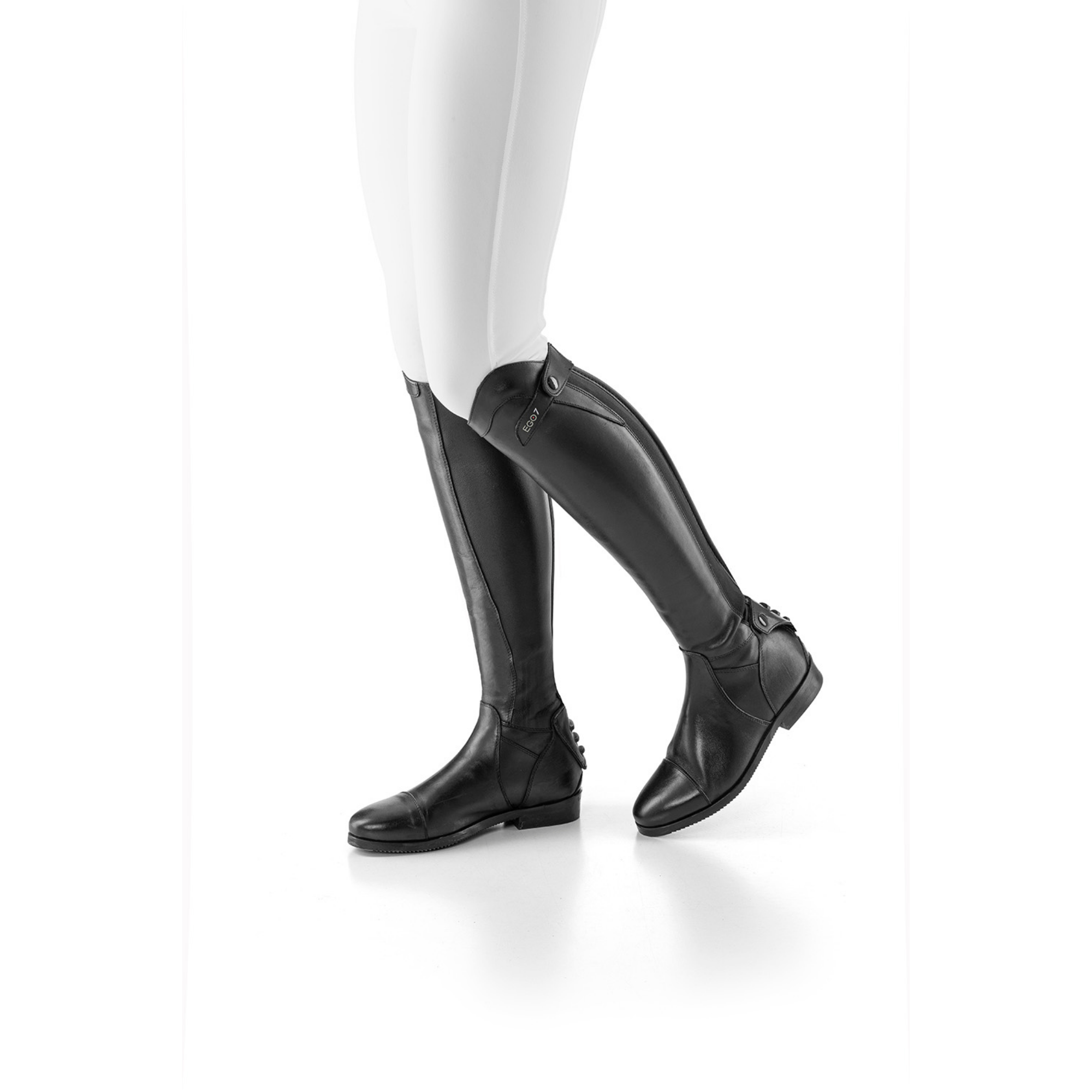 Side profile of EGO7 Aries black leather dress riding boots worn with white breeches, showing the contoured tall boot fit and rear zipper detail.
