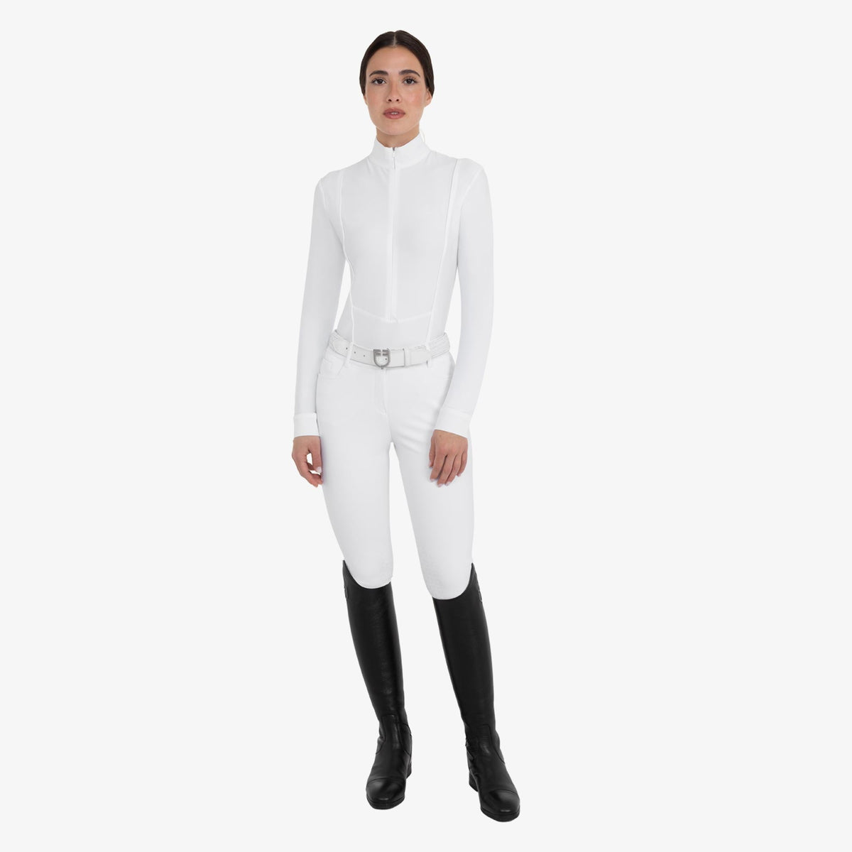 Equestro Women's Winter Competition Polo in White worn with breeches and tall boots