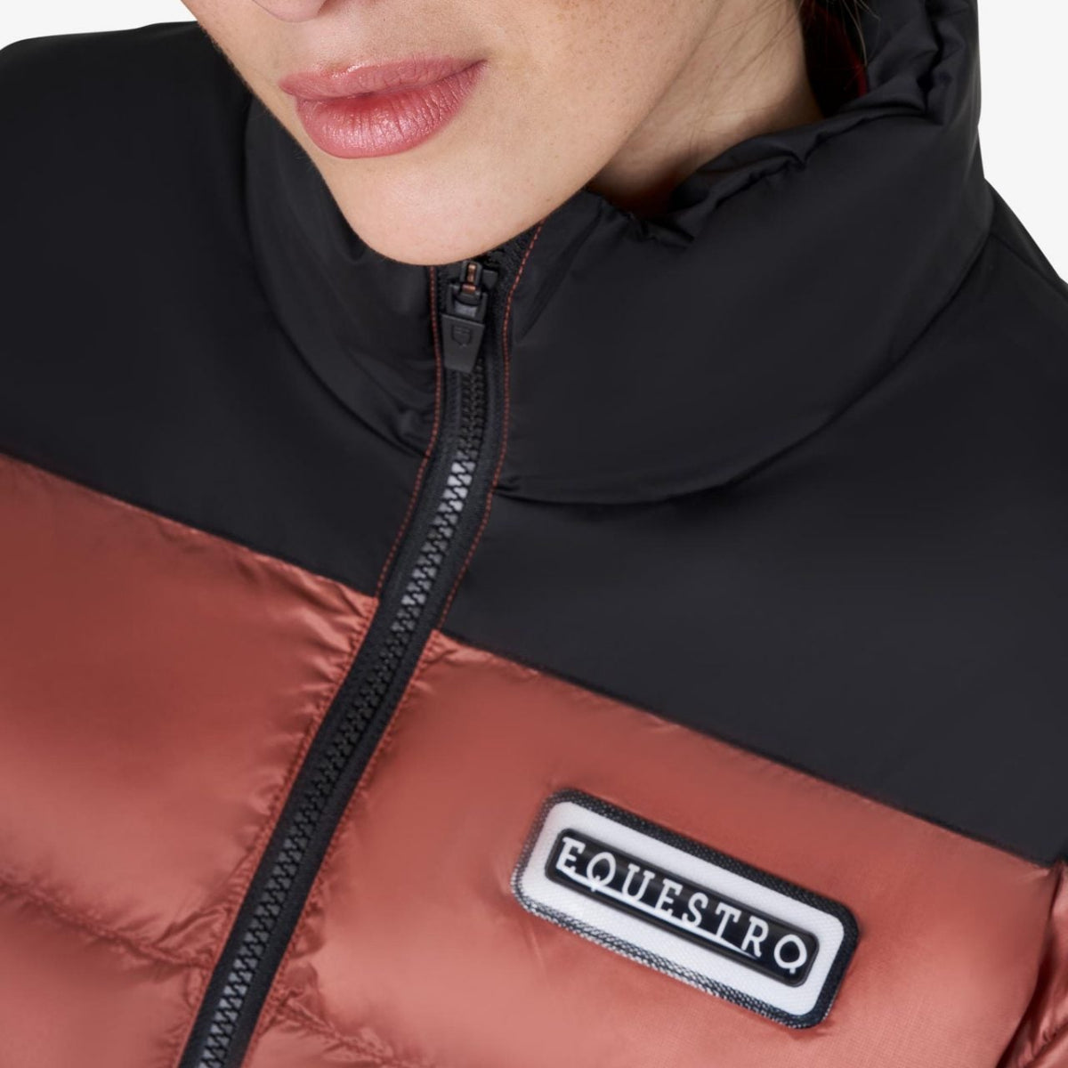 Equestro Cropped Puffer Jacket - Redwood & Black; chest logo detail, shown on woman on white background | Ladies Outerwear | Malvern Saddlery