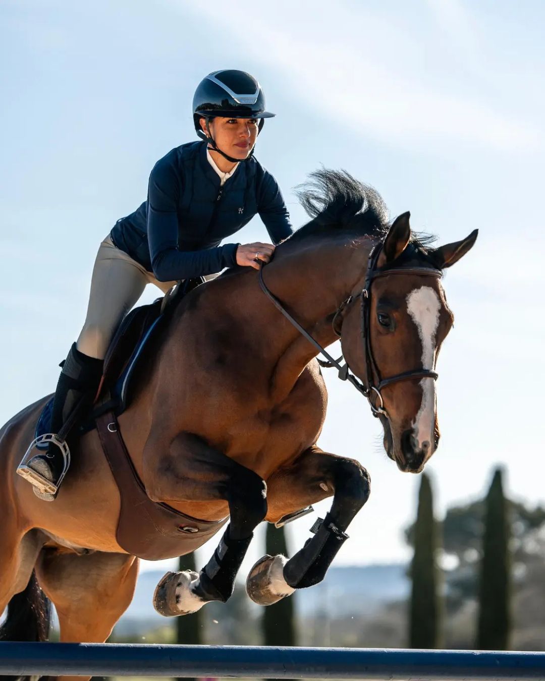 Horse Pilot Women's Storm Jacket - Navy, shown on rider on horse jumping over rails | Equestrian Outerwear | Malvern Saddlery