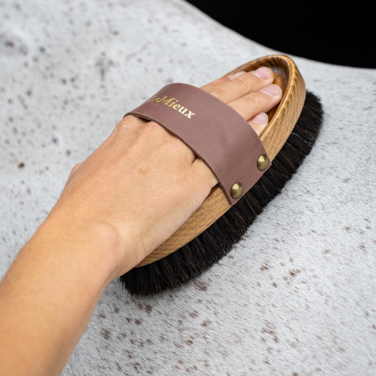 LeMieux Artisan Lambswool Body Brush - Brown with black bristles; shown with hand brushing gray horse | Horse Grooming | Malvern Saddlery