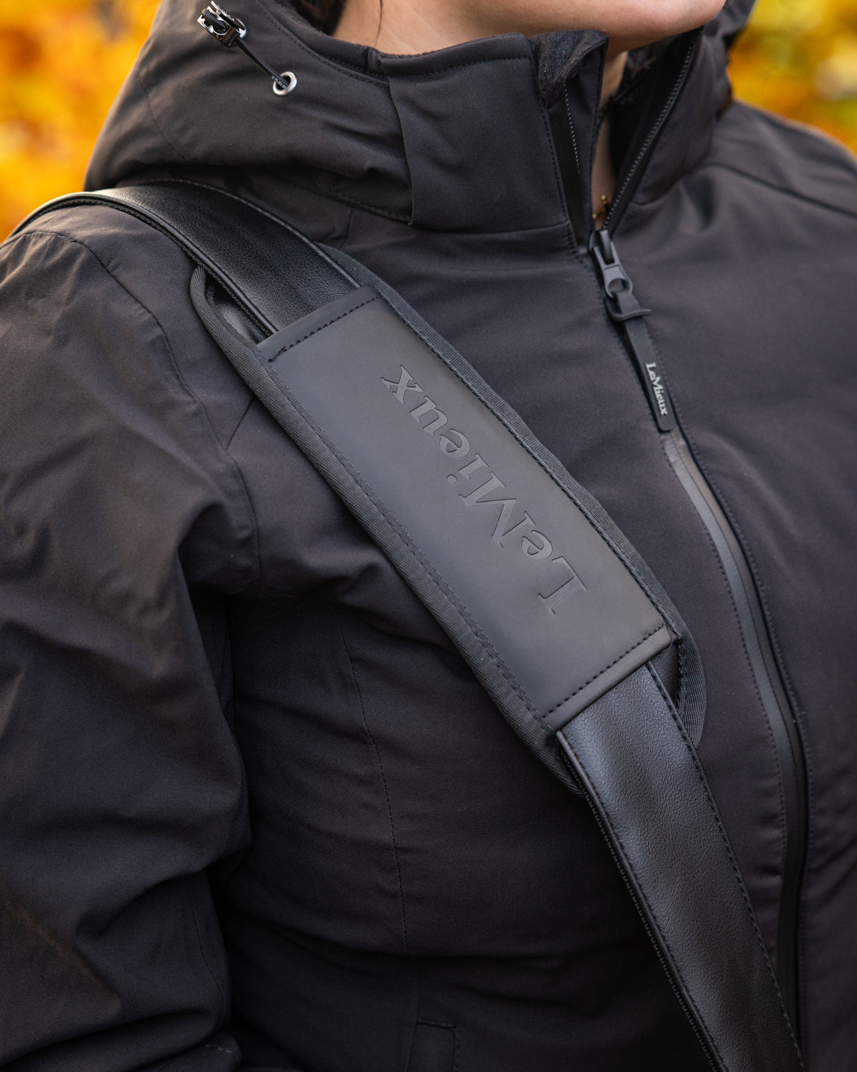 LeMieux Luxe Boot Bag - Black - detail of strap worn by person | Rider Travel Bags | Malvern Saddlery