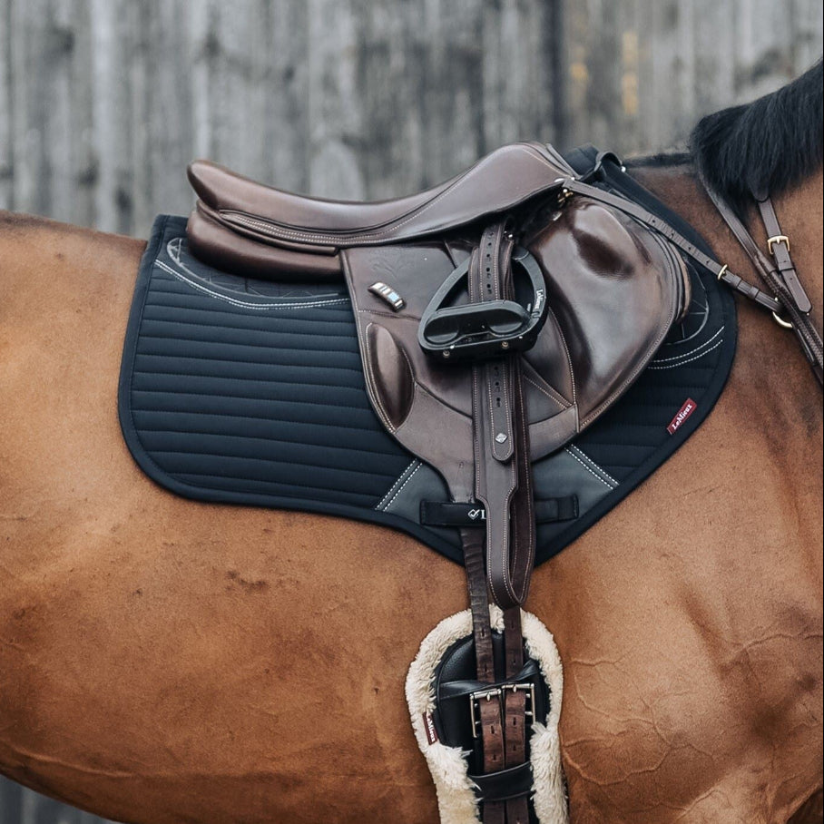 LeMieux Soft Shell Anti Slip Close Contact Saddle Pad - Black; shown on horse on gray barn background | Tack Shop | Malvern Saddlery
