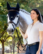 LeMieux Puissance Ear Bonnet - Navy, shown on gray horse with bridle and rider | Malvern Saddlery