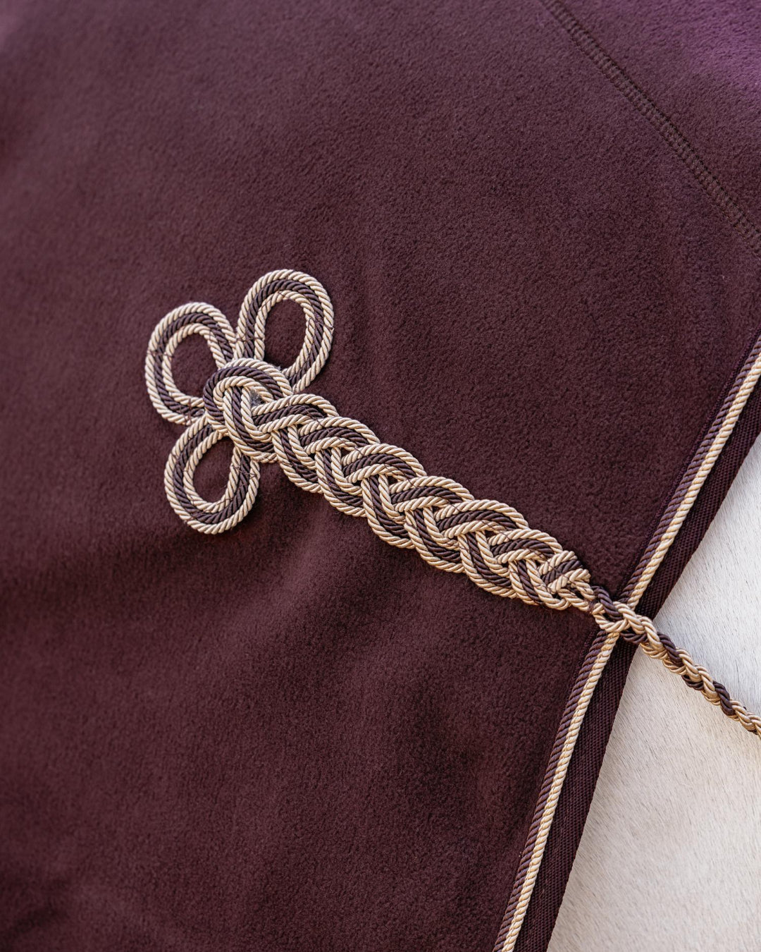 LeMieux Kudos Luxe Fleece Blanket - Damson; detail of braided ornament | Horse Blankets | Malvern Saddlery