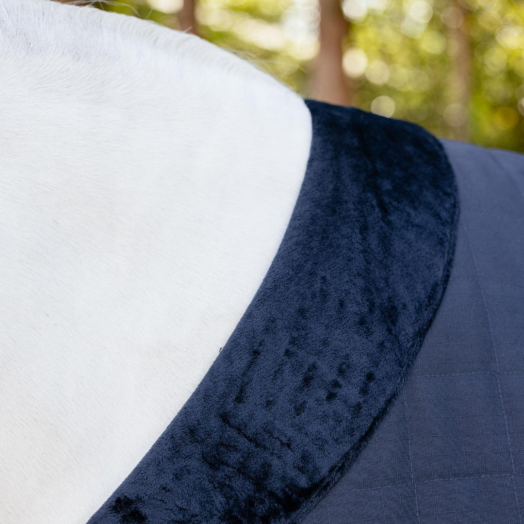 LeMieux Kudos Luxe Lined Stable Rug Navy; faux fur collar detail shown on horse with trees in background | Malvern Saddlery