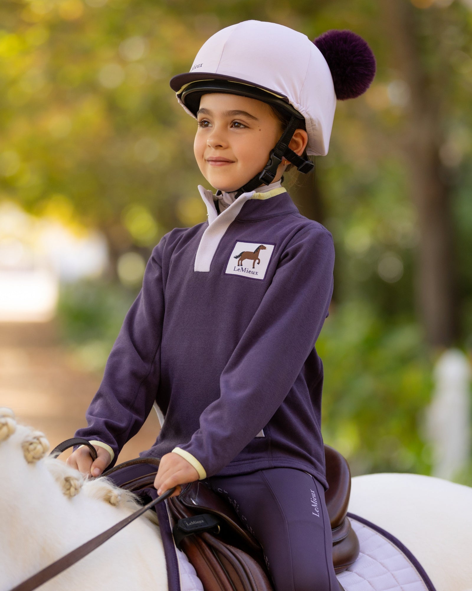 LeMieux Mini Mae Popper Fleece - Juniper Purple Pullover - shown on young girl on horse | Children's Activewear | Malvern Saddlery