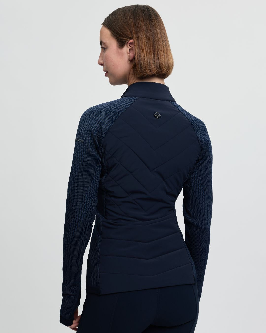 LeMieux Women's Maddie Hybrid Jacket - Navy; back view shown on person, white background | Riding Apparel | Malvern Saddlery