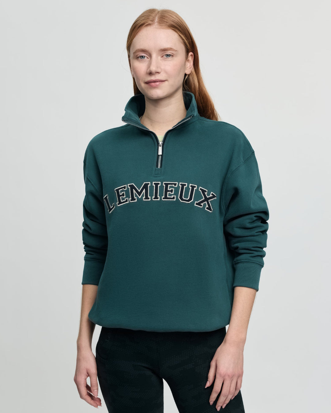 LeMieux Kelsie Quarter Neck Sweatshirt - Jungle Green; shown on person against gray background | Malvern Saddlery