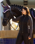 LeMieux Maddie Hybrid Jacket - Black, shown on woman standing next to horse | Ladies Outerwear | Malvern Saddlery