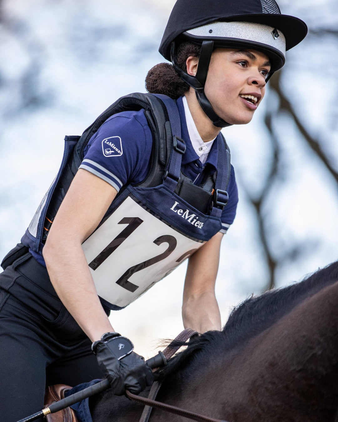 LeMieux Eventing Bib - Navy, shown on rider on brown horse | Rider Accessories | Malvern Saddlery