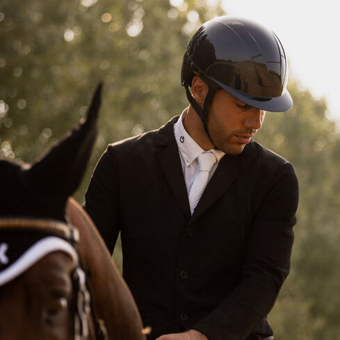 KASK Kooki Equestrian Helmet, Navy Shine, shown on man wearing show coat on horse | Malvern Saddlery