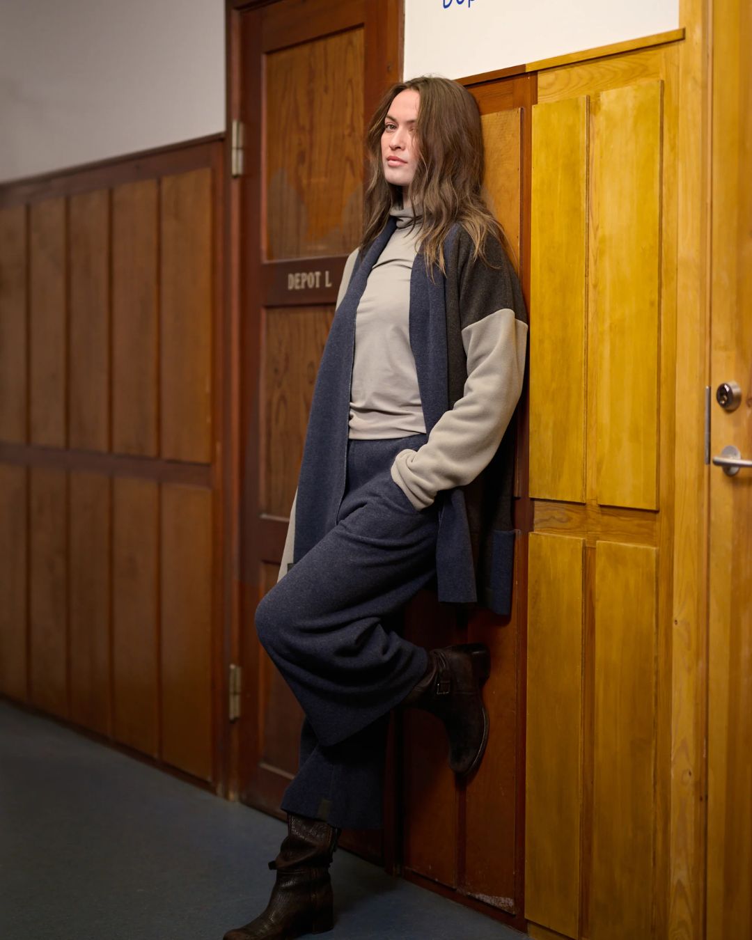 Luxe Fleece Patch Women's Cardigan - Evening Blue/Chocolate/Elephant Gray; worn by woman leaning against wood wall | Malvern Saddlery