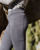 Schockemoehle Sports Ladies SP Dorina Full Seat Riding Tights - Dusty Chocolate Gray; side view shown on woman next to horse | Women's Riding Apparel | Malvern Saddlery