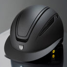 Tipperary Oxford Shimmer MIPS® Wide Brim Helmet - Black with Matte/Gloss trim; shown on reflective surface with gray background | Equestrian Helmets | Malvern Saddlery