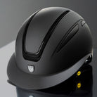 Tipperary Oxford Shimmer MIPS® Wide Brim Helmet - Black with Glimmer/Gloss trim; shown reflective surface, gray background | Equestrian Helmets | Malvern Saddlery