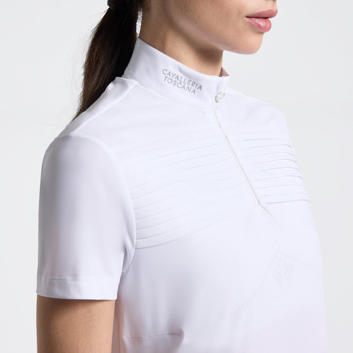 Cavalleria Toscana Women's Short Sleeve Pleated Competition Shirt - White; close up neck and chest on model on white background | Equestrian Show Shirts | Malvern Saddlery
