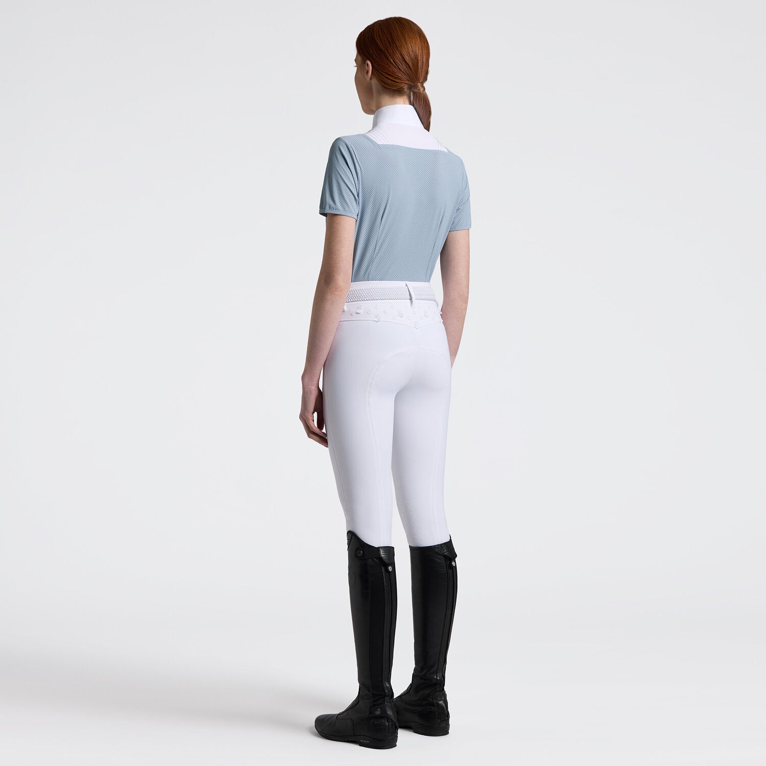 Cavalleria Toscana Women's Competition Shirt in Technical Jersey with white poplin colllar & hidden buttons - light blue, shown on model with white breeches, riding boots - back view | Equestrian Show Shirts  | Malvern Saddlery