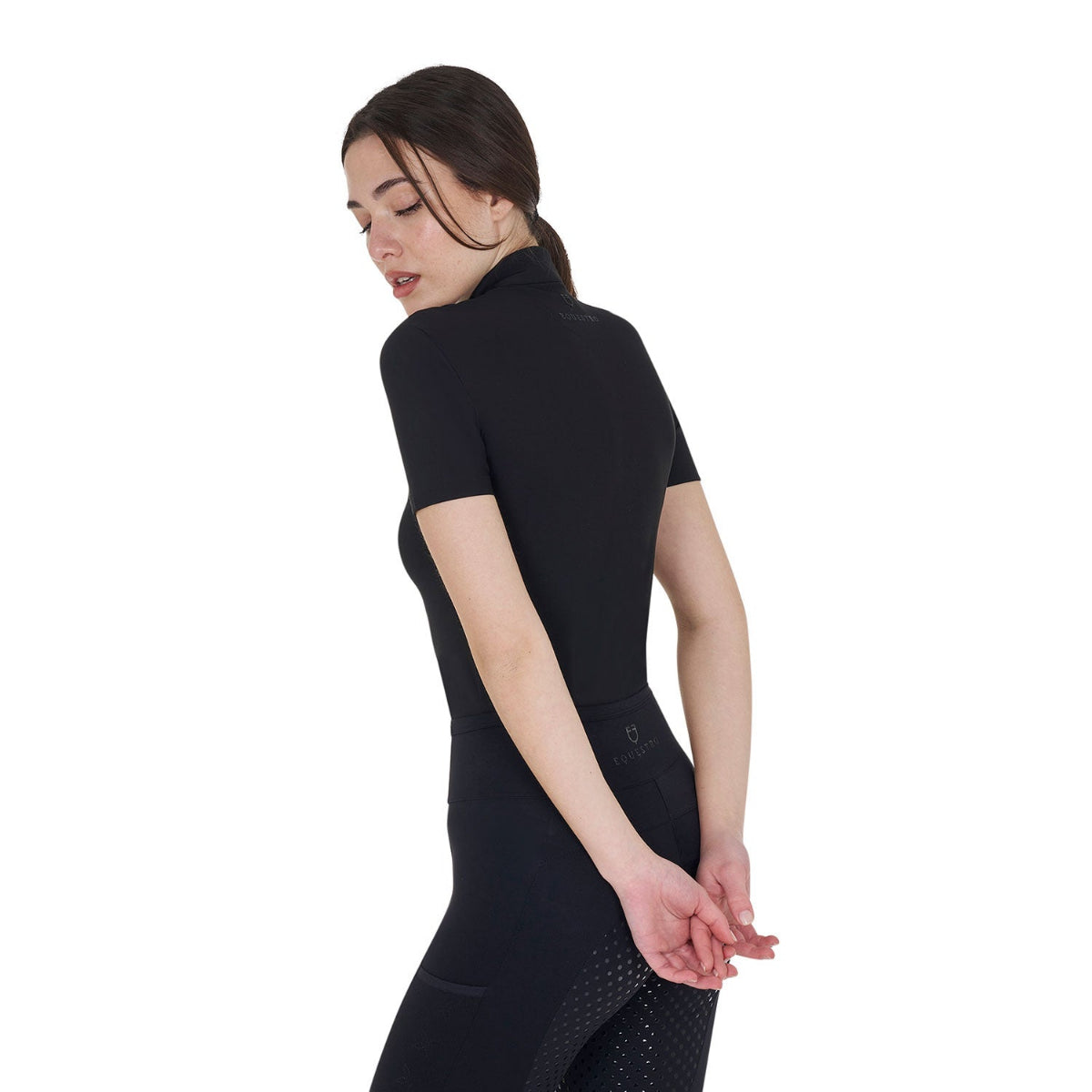 Equestro Women's Training Polo Quarter Zip with beaded collar detail - Black; back left view, shown on woman, white background | Riding Shirts | Malvern Saddlery