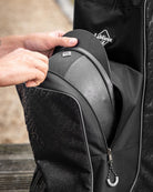LeMieux Elite Pro Helmet & Boot Bag - Black, close up of person removing helmet from bag| Equestrian Accessories | Malvern Saddlery