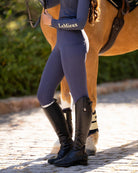 LeMieux Young Rider Orla Pull Ons - Dusk Blue, shown on model next to horse | Malvern Saddlery