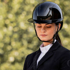 KASK Kooki Lady Equestrian Helmet - Black Shine; shown on rider with blurred outdoor background | Wide Brim Helmets | Malvern Saddlery