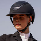 KASK Star Lady Chrome Equestrian Helmet - Navy; close up shown on woman with blue sky background | Wide Brim English Riding Helmets | Malvern Saddlery