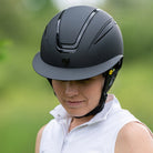 Tipperary Oxford Shimmer MIPS® Wide Brim Helmet - Black with Glimmer/Gloss trim; shown on rider with blurred outdoor background | Equestrian Helmets | Malvern Saddlery