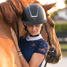 Tipperary Equestrian Windsor MIPS® Wide Brim Helmet; Black Matte with Smoked Chrome; shown on woman with horse | Malvern Saddlery