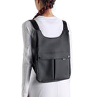 Black EGO7 Rosalie Backpack worn over a white long-sleeve equestrian top showing back pockets and branded straps