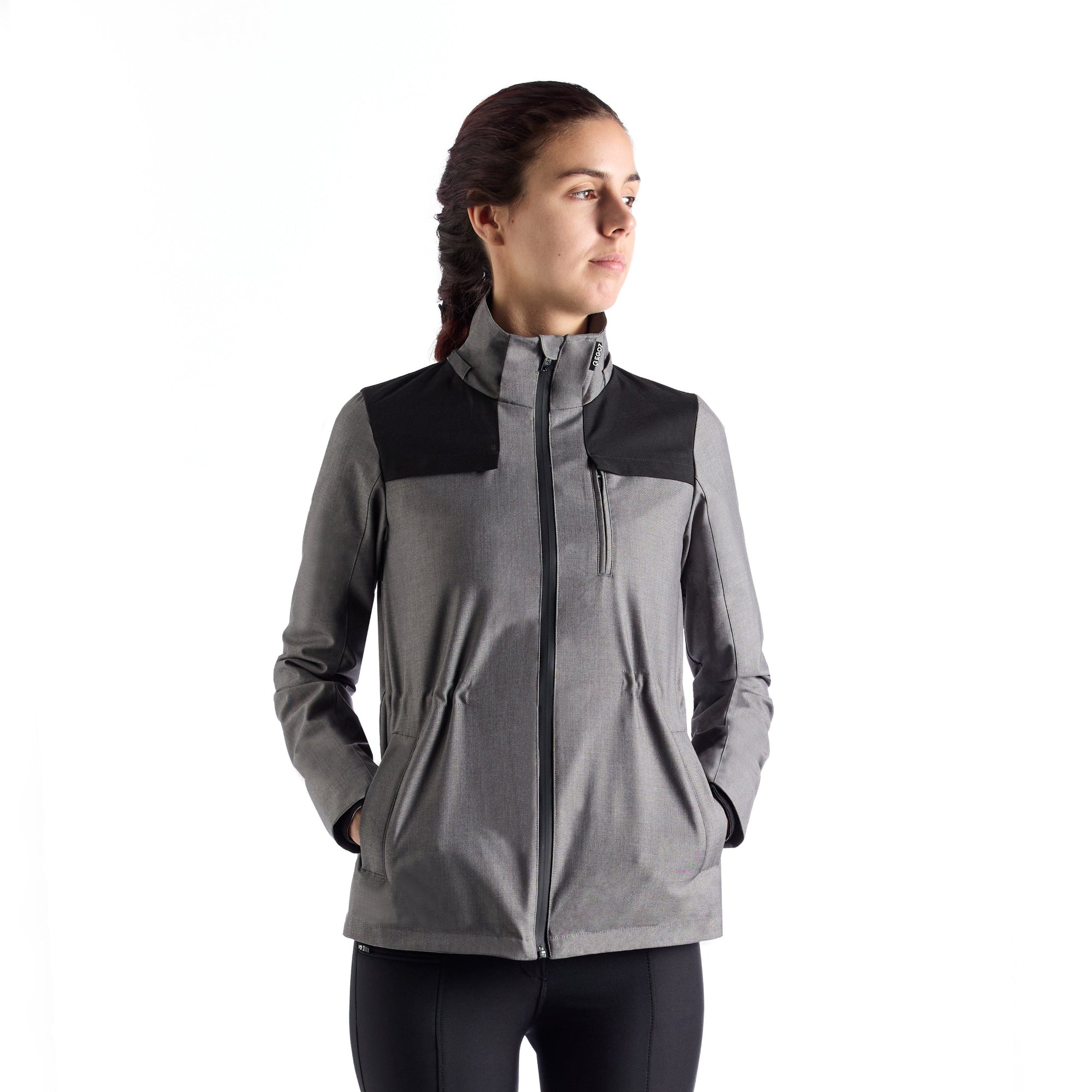 Female rider wearing the EGO7 Skye women's waterproof equestrian jacket in melange grey with black shoulder panels.