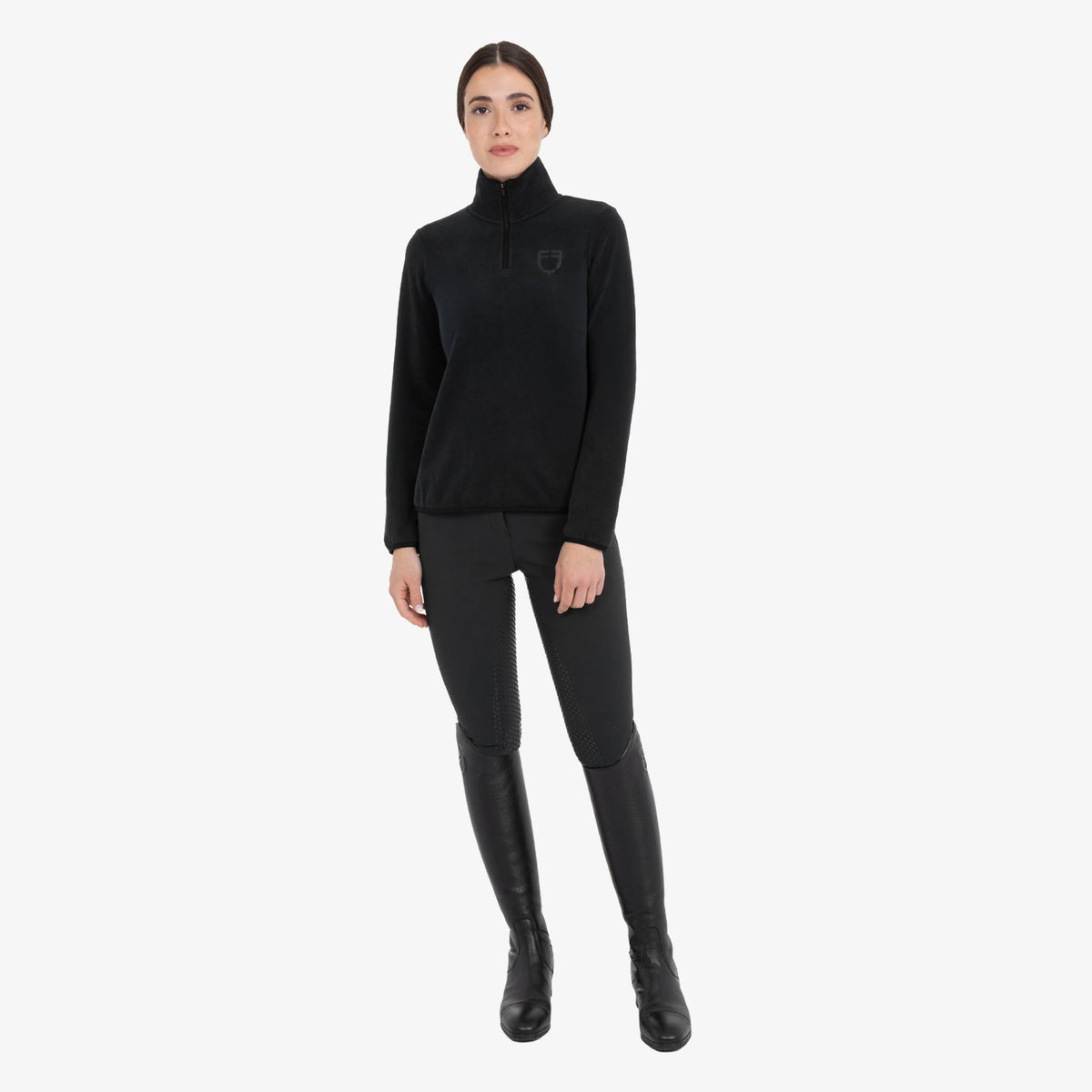 Equestro Women's High Neck Fleece 3/4 Zip Sweatshirt in Black worn with breeches and tall boots