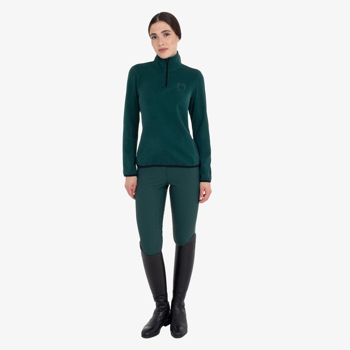 Equestro Women's High Neck Fleece 3/4 Zip Sweatshirt in Pine Grove worn with breeches and tall boots