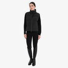 Equestro Women's High Collar Padded Vest in Black worn with breeches and tall boots