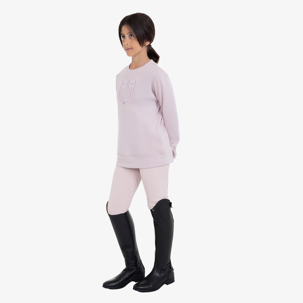 Equestro Kids' Unisex Crewneck Fleece Sweatshirt in Hushed Violet worn with riding boots