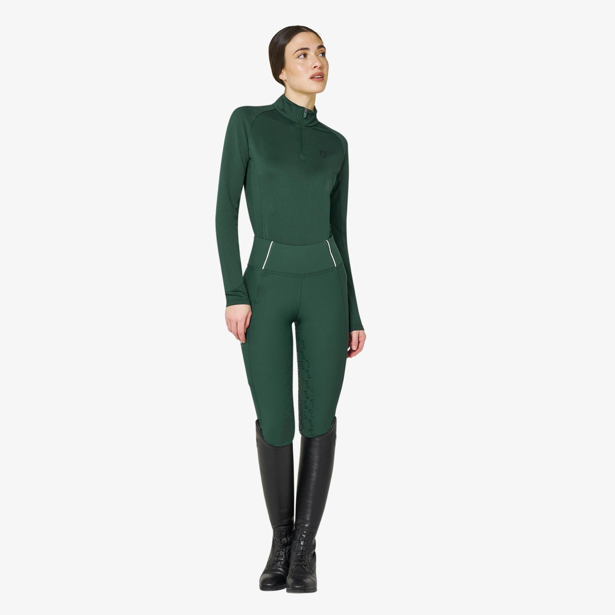 Equestro Women's Slim Fit Long Sleeve Base Layer in Pine Grove worn with breeches and tall boots