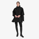 Equestro Women's Technical Rain Cape in Black worn with breeches and tall boots