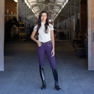Halter Ego Women's Evolution Mid Waist Full Grip Breeches - Dark Plum, front view on model in barn aisle | Malvern Saddlery