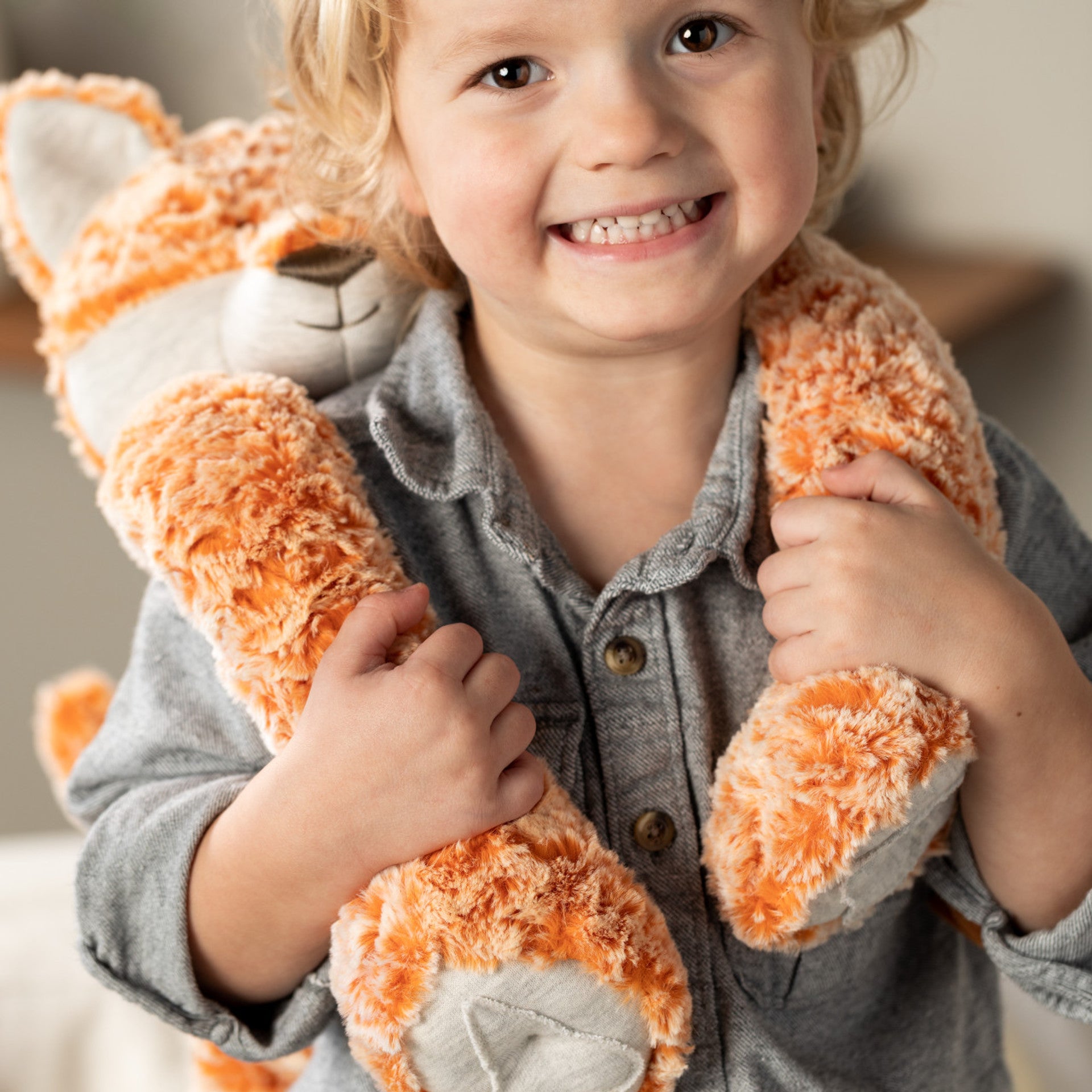 Heartful Hugs Fox - weighted plush, wrapped around shoulders of smiling child | Malvern Saddlery