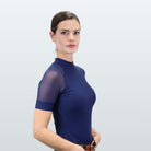 Kismet Ren Half Zip Riding Shirt - Blue; worn by woman on gray background | Schooling Shirts | Malvern Saddlery