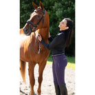 KL Select Gabrielle Full Seat Breeches - Blackberry, shown on Woman in equestrian attire standing next to a brown horse outdoors | Malvern Saddlery