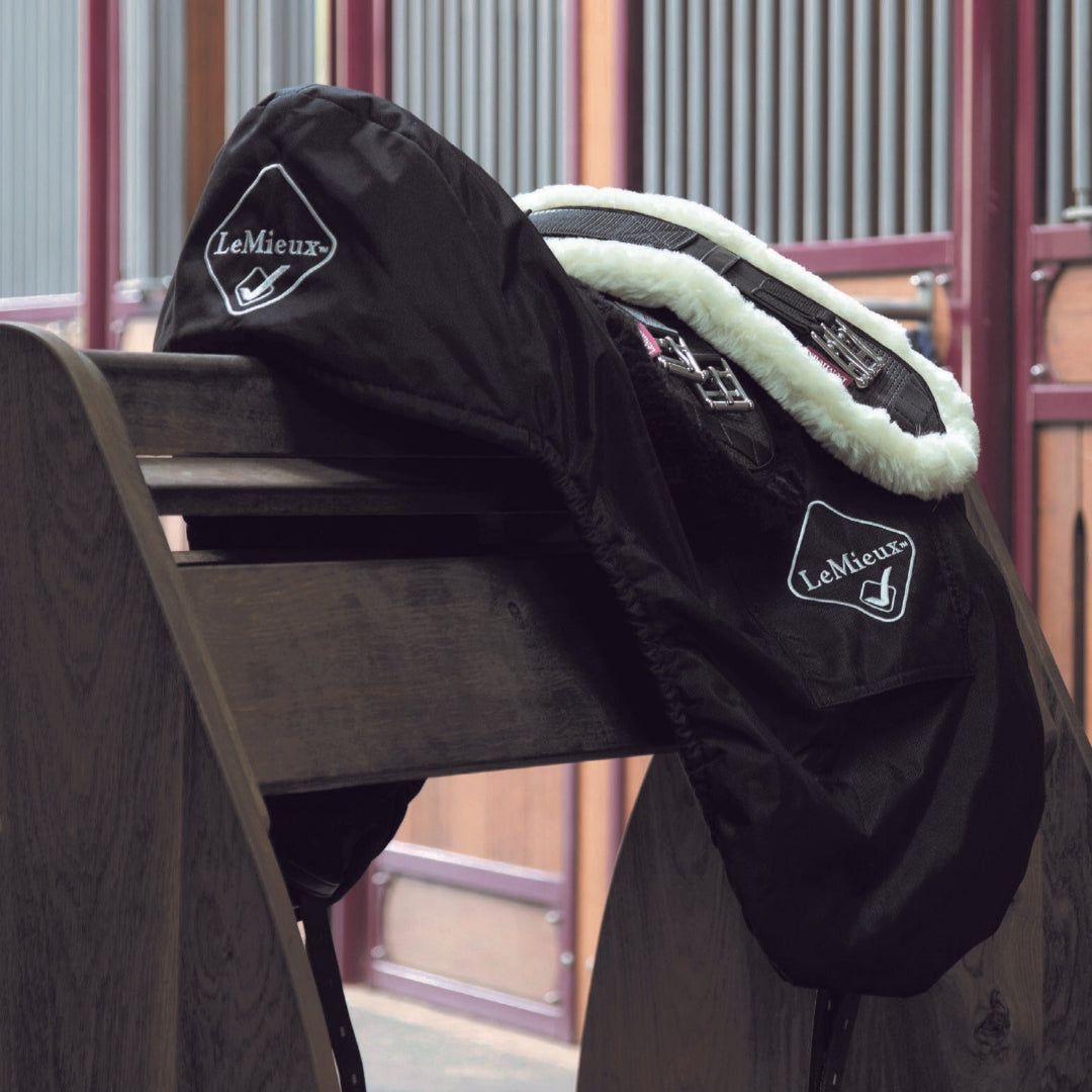 LeMieux  ProKit Saddle Cover - Dressage, Black shown with fleece lined girth on saddle stand in stable | Tack Shop | Malvern Saddlery