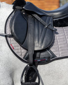 LeMieux Vector Pro Stirrup Leathers- Black, shown on gray horse with saddle & stirrups | Tack Shop | Malvern Saddlery